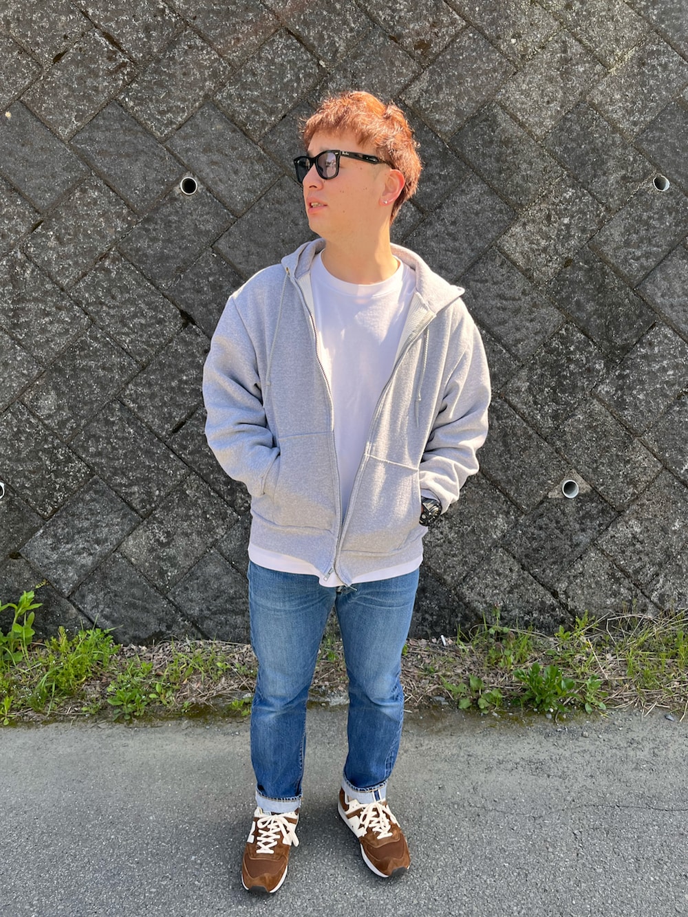 グレー系のパーカー、ホワイト系のTシャツ/カットソー、ブルー系のデニムパンツを着用したメンズの春コーディネートの3枚目の写真