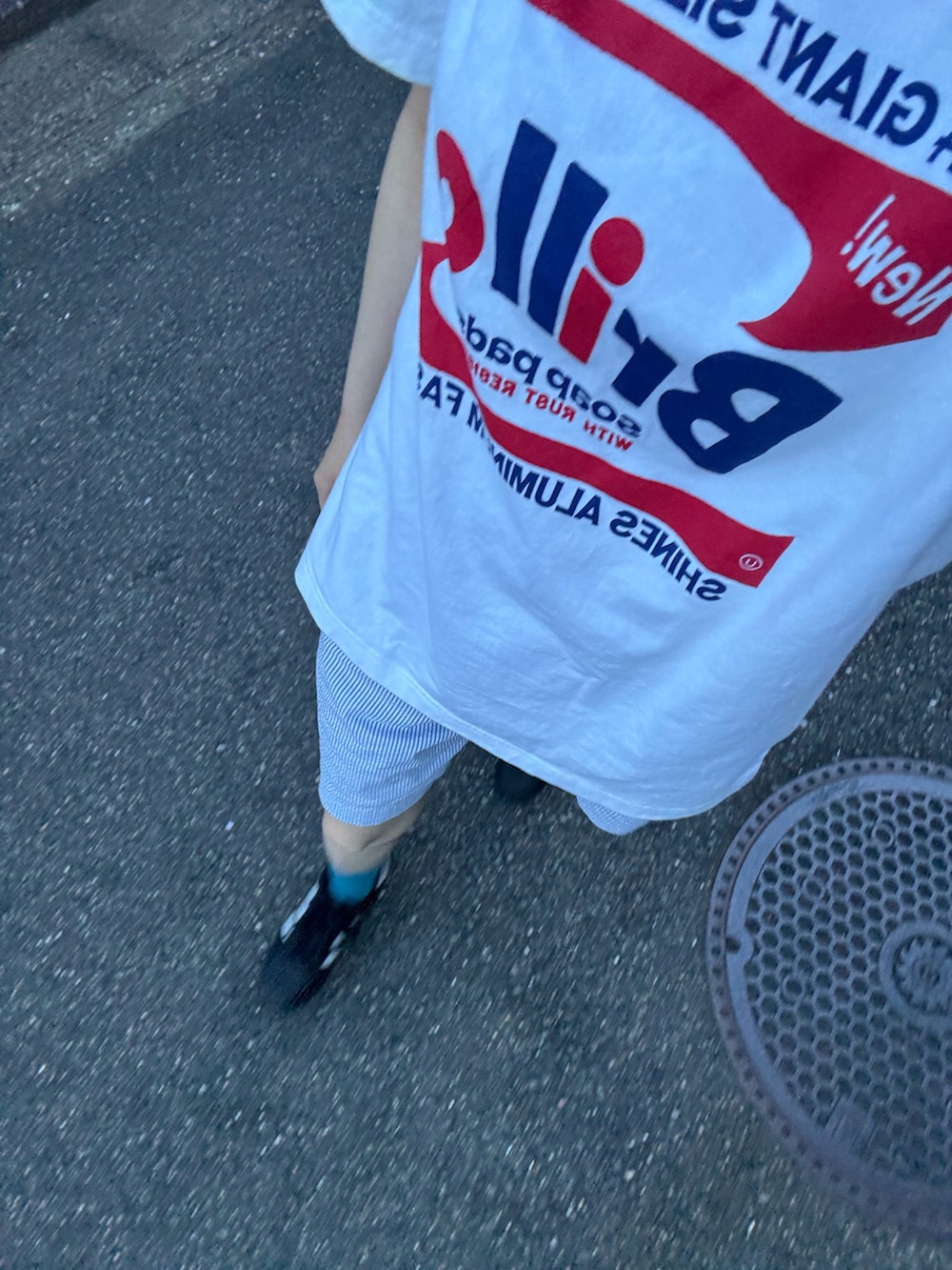 ホワイト系のTシャツ/カットソー、ブルー系のパンツ、ブラック系のスニーカーを着用したレディースの秋コーディネートの2枚目の写真