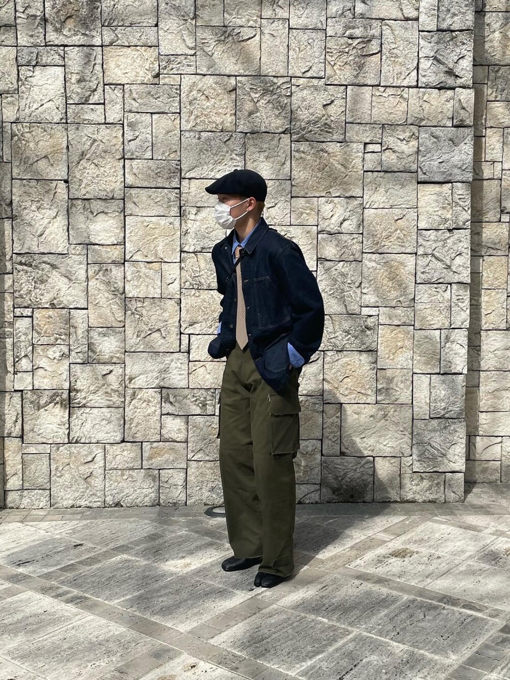 ブラック系のシューズ、グリーン系のカーゴパンツ、ブルー系のデニムジャケットを着用したメンズの春コーディネートの2枚目の写真
