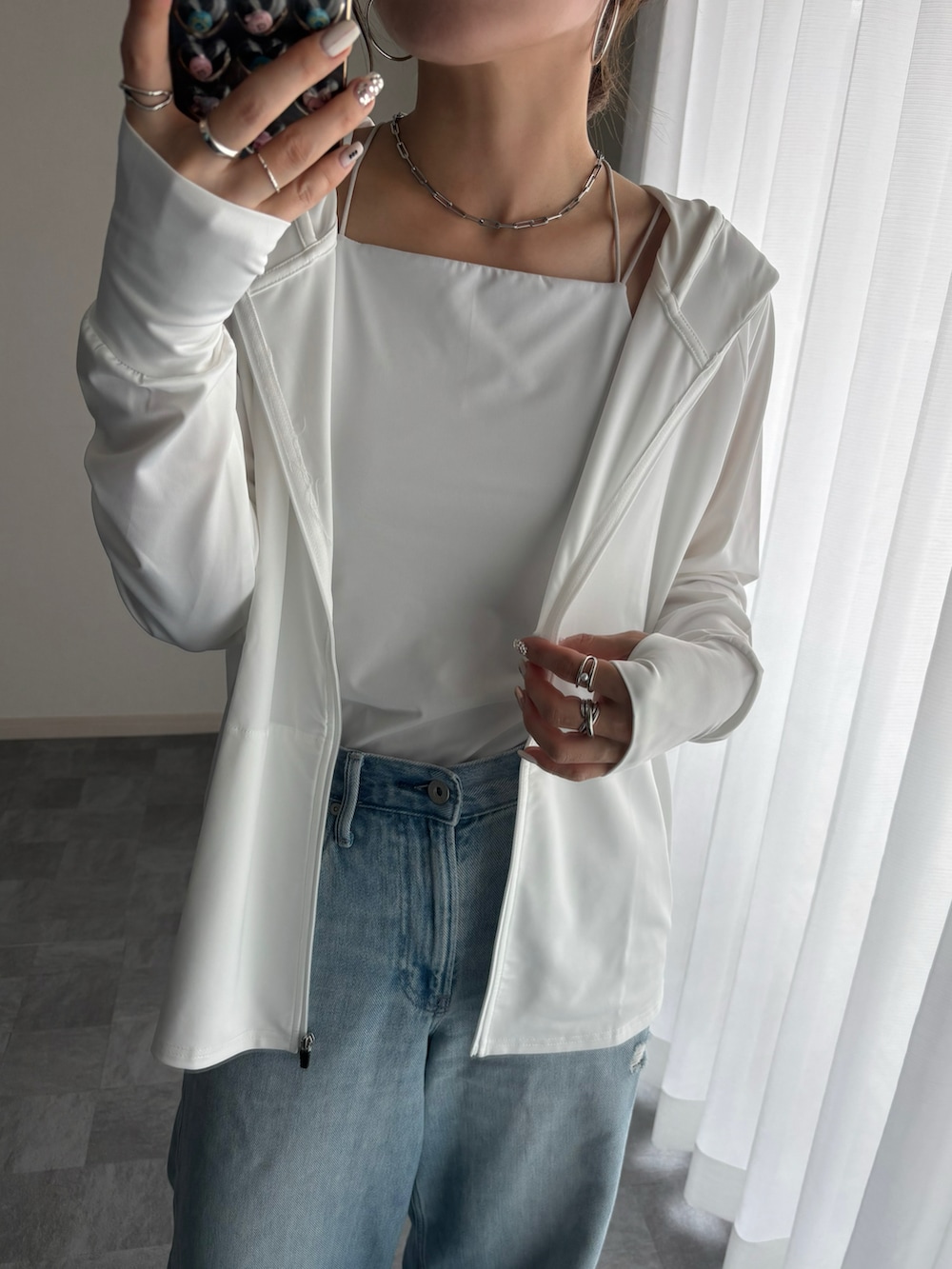 ホワイト系のパーカーを着用したレディースの春コーディネートの2枚目の写真