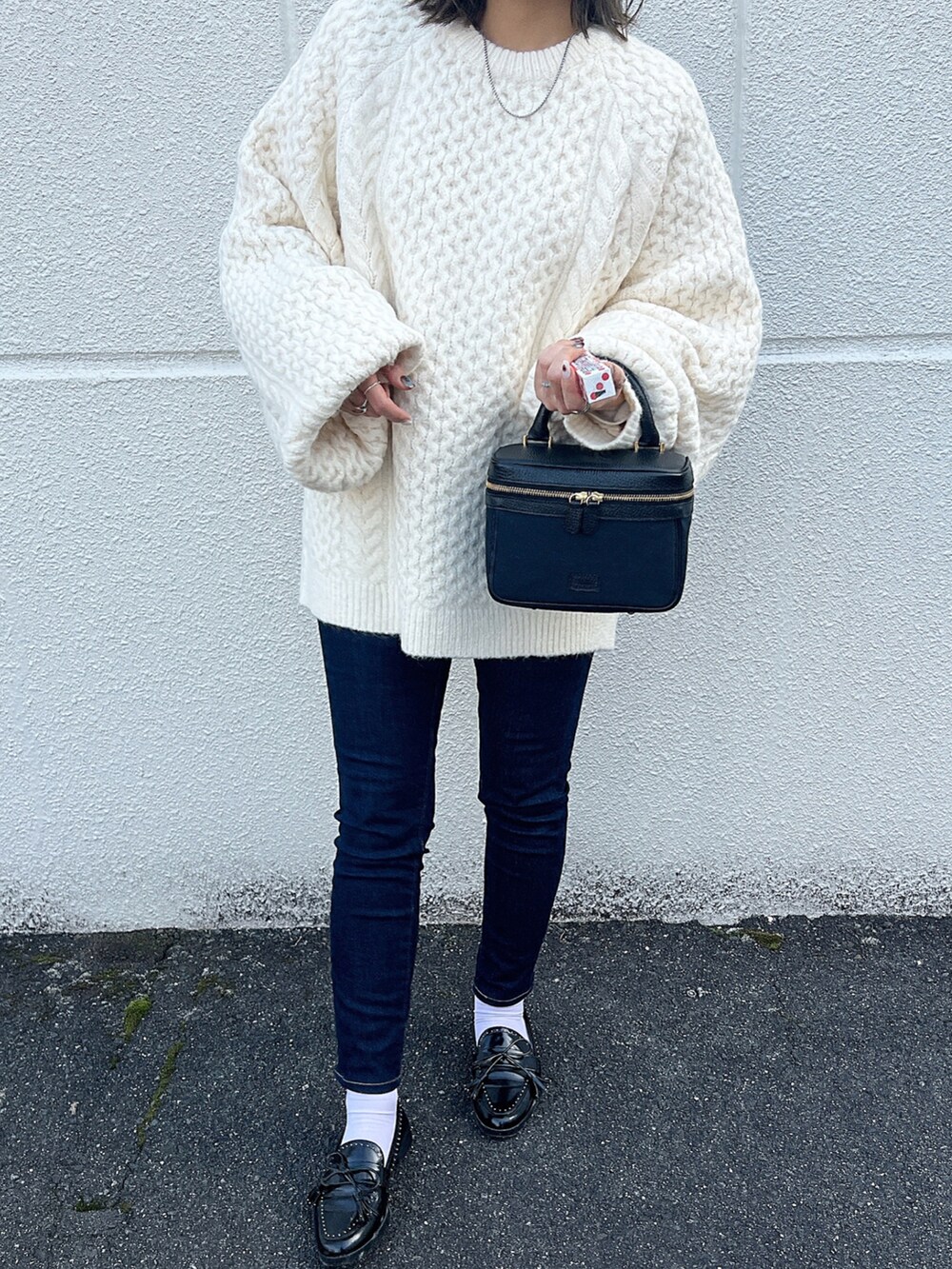ブルー系のデニムパンツ、ブラック系のローファー、ブラック系のハンドバッグを着用したレディースの冬コーディネートの4枚目の写真