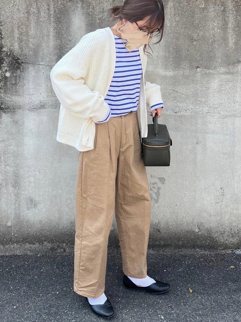 グリーン系のバッグ、ベージュ系のチノパンツ、ブルー系のTシャツ/カットソーを着用したレディースの春コーディネートの2枚目の写真