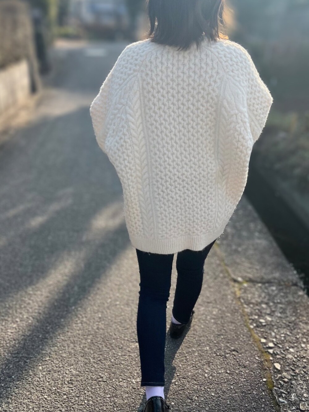 ブルー系のデニムパンツ、ブラック系のローファー、ブラック系のハンドバッグを着用したレディースの冬コーディネートの2枚目の写真