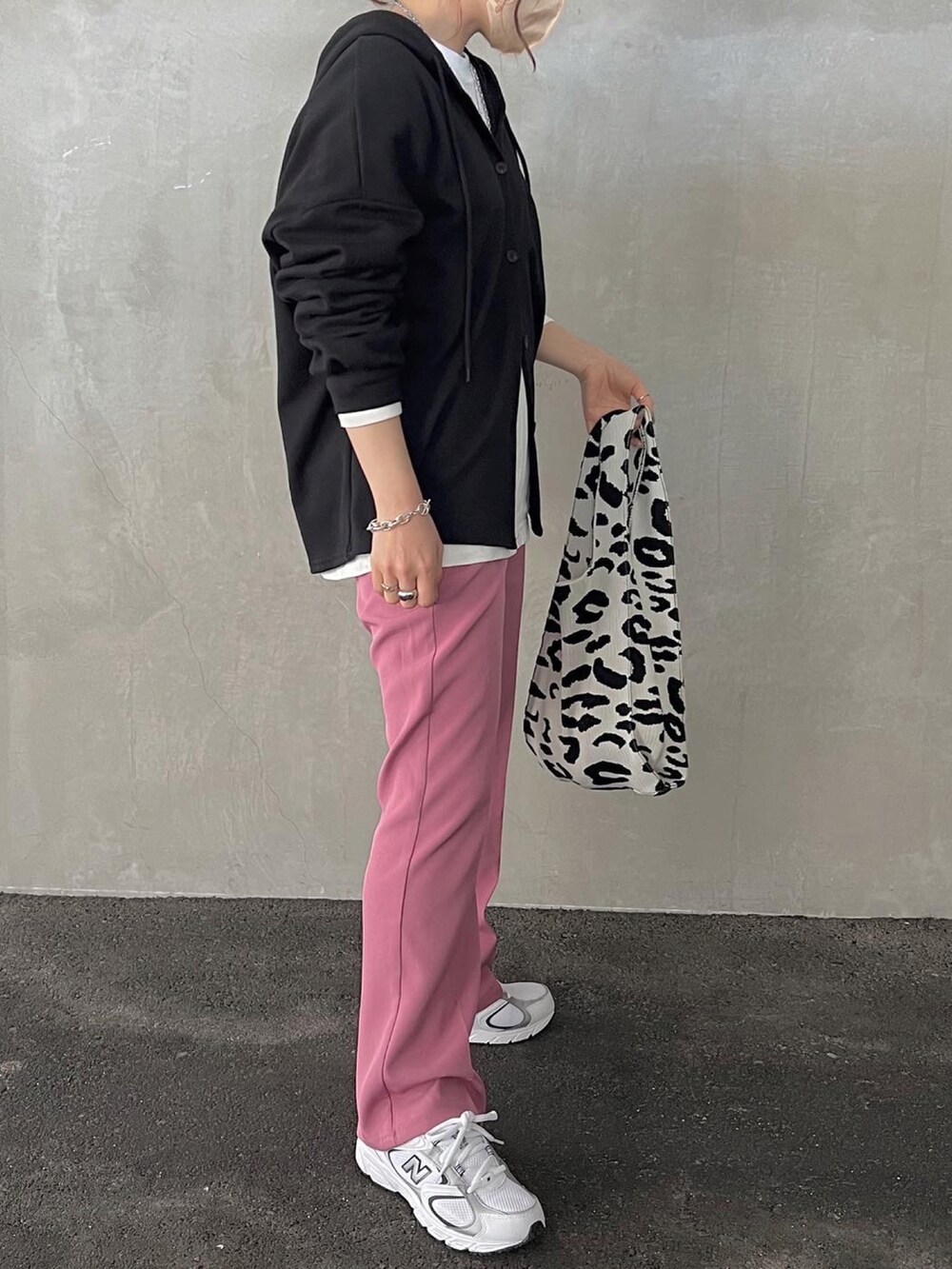 ピンク系のスラックス、ホワイト系のスニーカー、ブラック系のスウェットを着用したレディースの春コーディネートの2枚目の写真