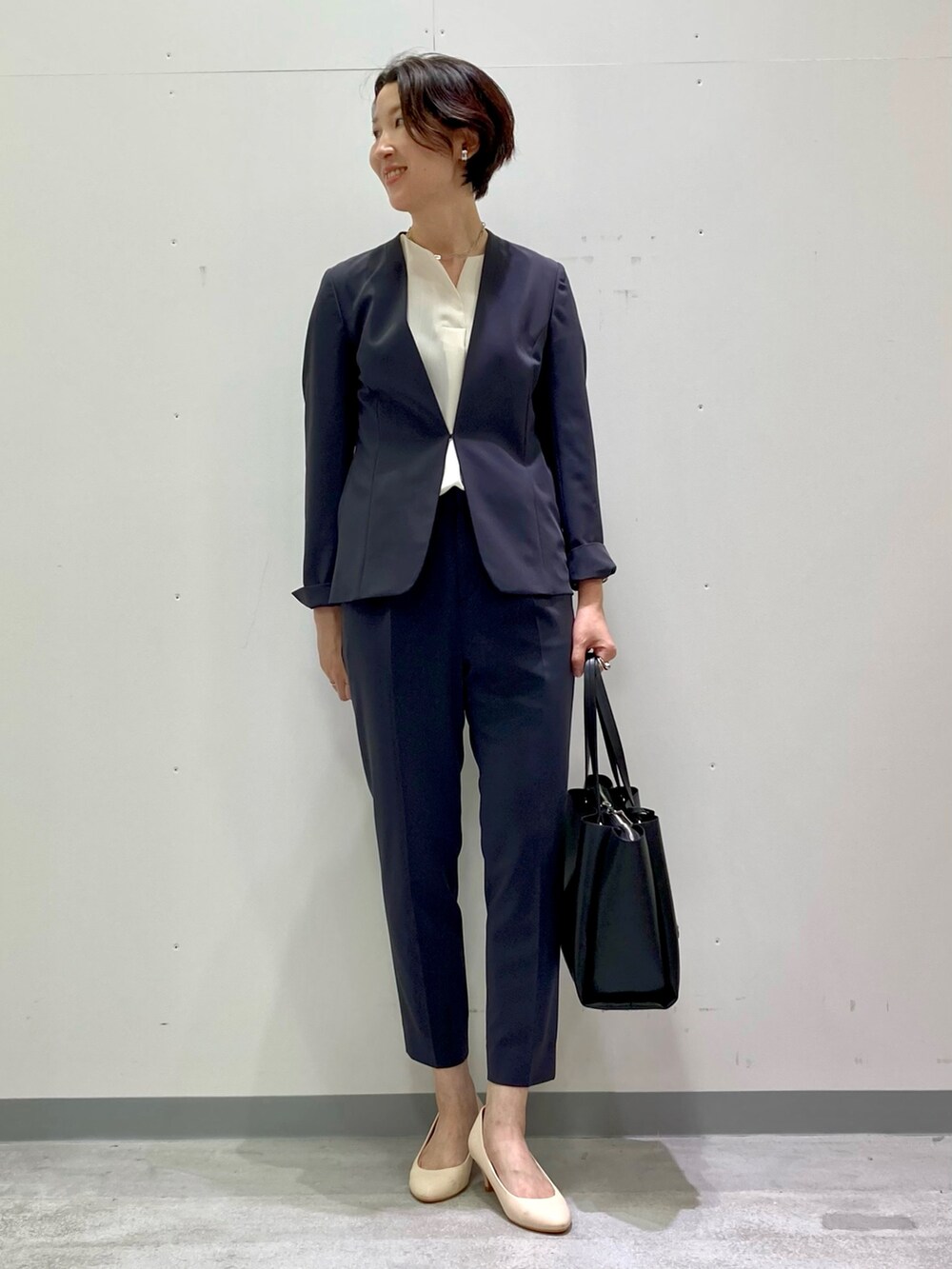 ホワイト系のシャツ/ブラウス、グレー系のスーツジャケット、グレー系のスーツパンツを着用したレディースの秋コーディネートの2枚目の写真