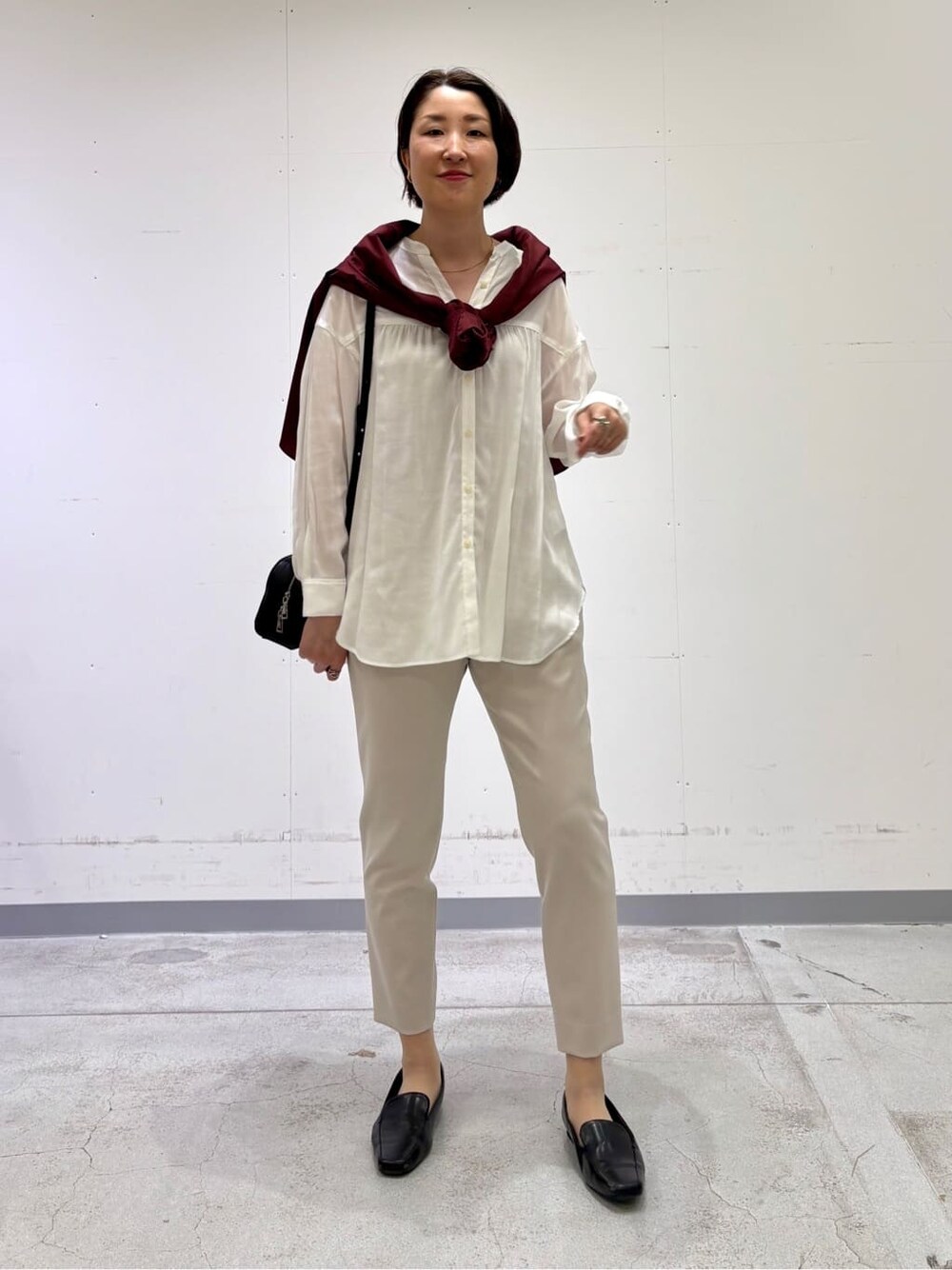 ホワイト系のシャツ/ブラウス、レッド系のニット/セーター、ベージュ系のその他パンツを着用したレディースの春コーディネートの7枚目の写真