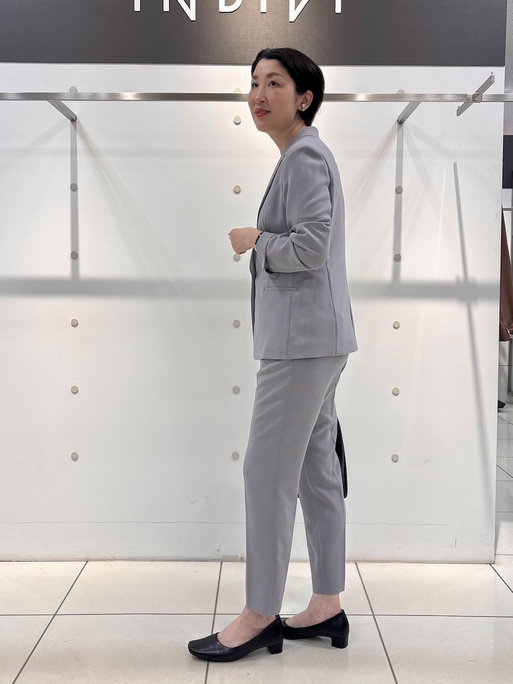 グレー系のスーツジャケット、グレー系のシャツ/ブラウス、グレー系のスーツパンツを着用したレディースの夏コーディネートの3枚目の写真