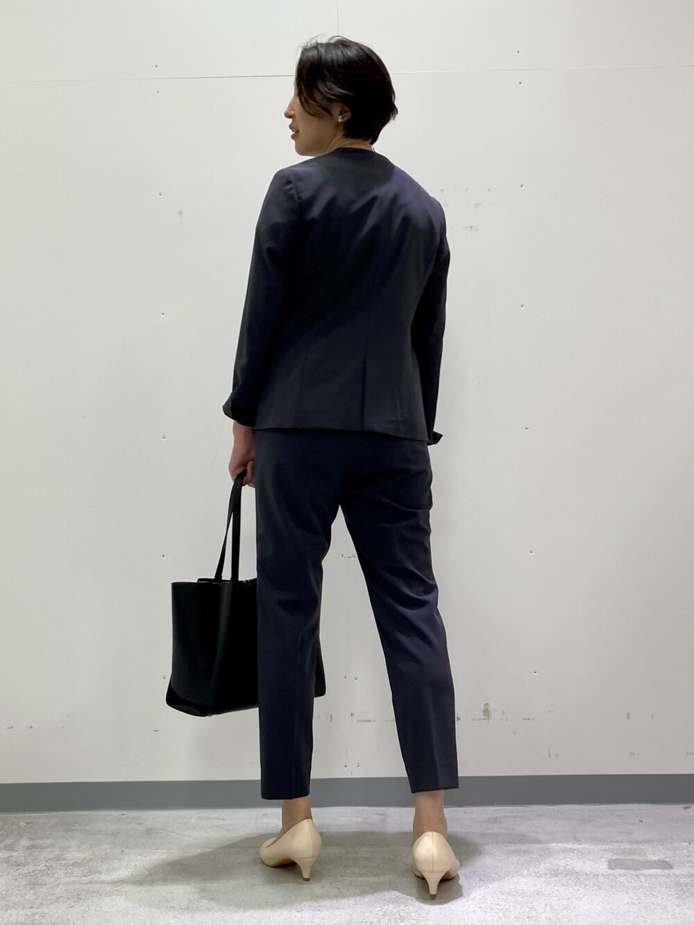 ホワイト系のシャツ/ブラウス、グレー系のスーツジャケット、グレー系のスーツパンツを着用したレディースの秋コーディネートの4枚目の写真