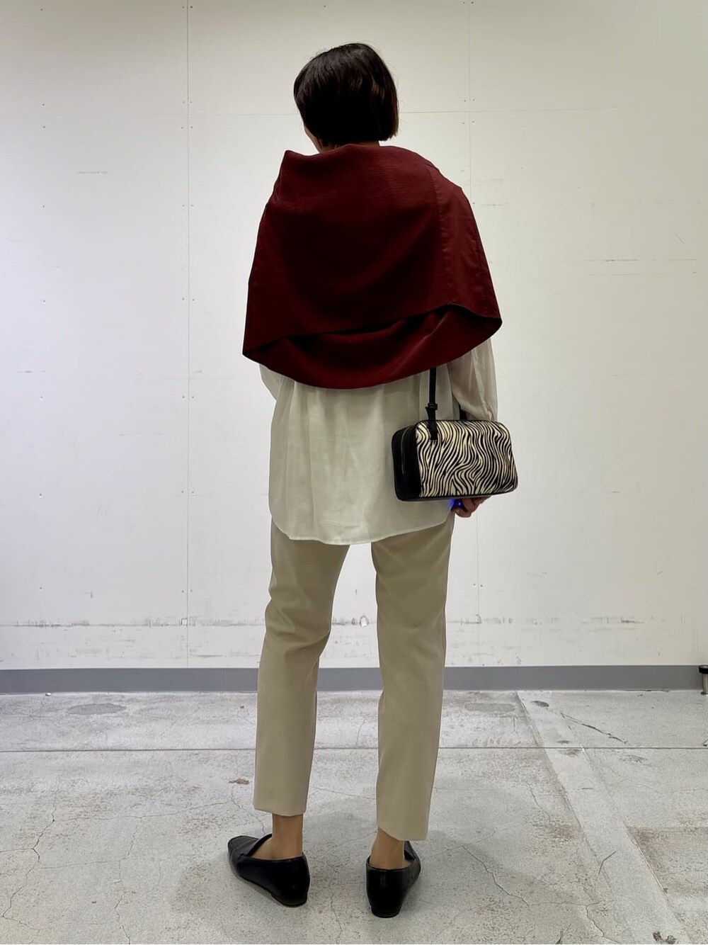 ホワイト系のシャツ/ブラウス、レッド系のニット/セーター、ベージュ系のその他パンツを着用したレディースの春コーディネートの4枚目の写真