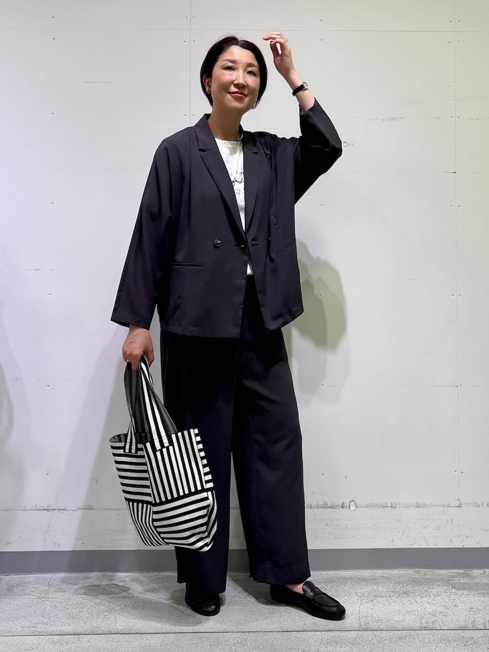 ブラック系のトートバッグ、ホワイト系のTシャツ/カットソー、グレー系のその他パンツを着用したレディースの春コーディネートの8枚目の写真