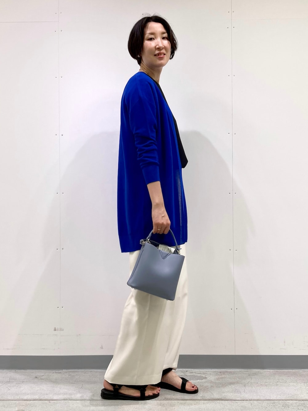 ブラック系のシャツ/ブラウス、ブルー系のカーディガン/ボレロ、ホワイト系のその他パンツを着用したレディースの秋コーディネートの2枚目の写真