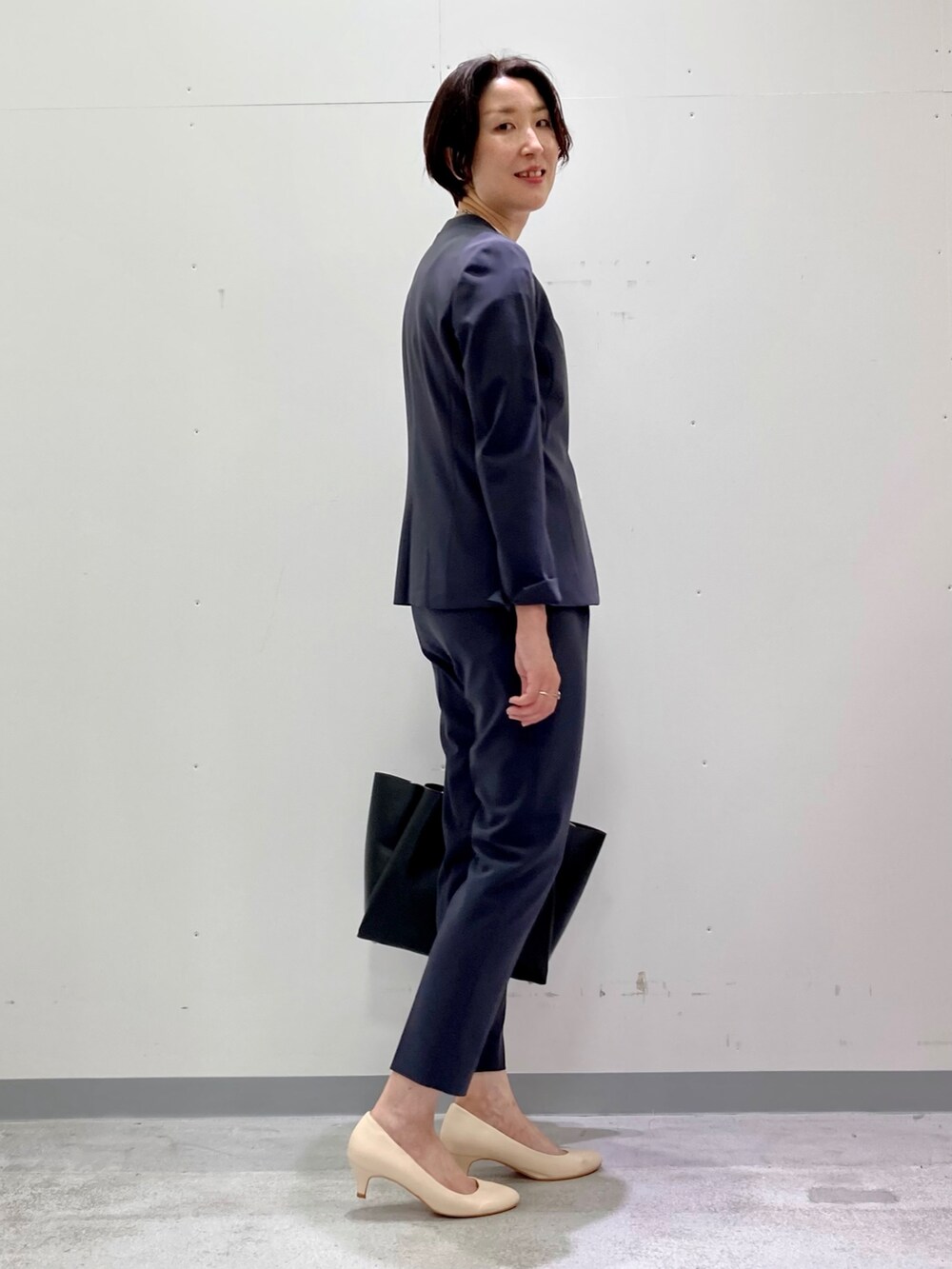 ホワイト系のシャツ/ブラウス、グレー系のスーツジャケット、グレー系のスーツパンツを着用したレディースの秋コーディネートの3枚目の写真