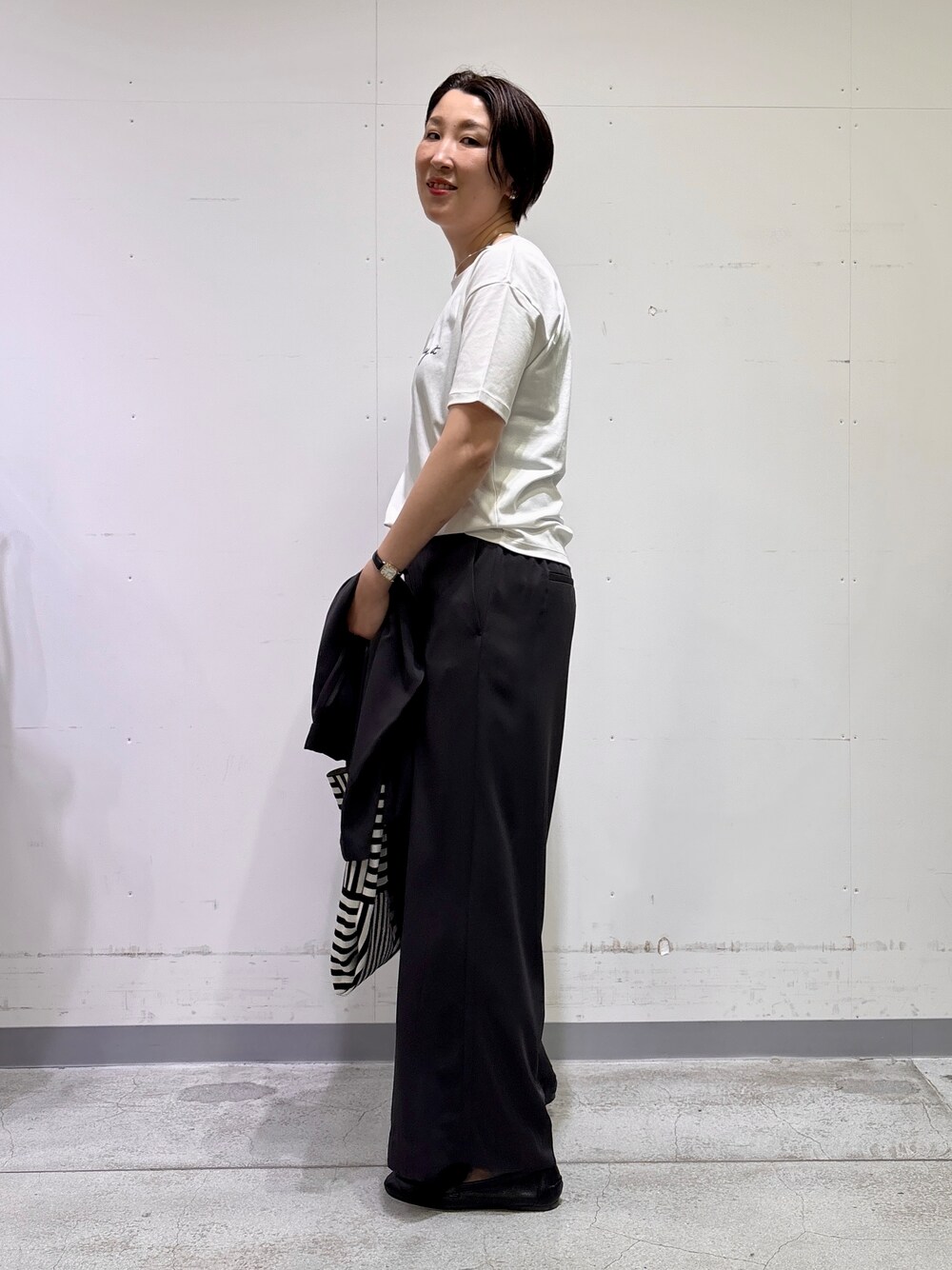 ブラック系のトートバッグ、ホワイト系のTシャツ/カットソー、グレー系のその他パンツを着用したレディースの春コーディネートの10枚目の写真