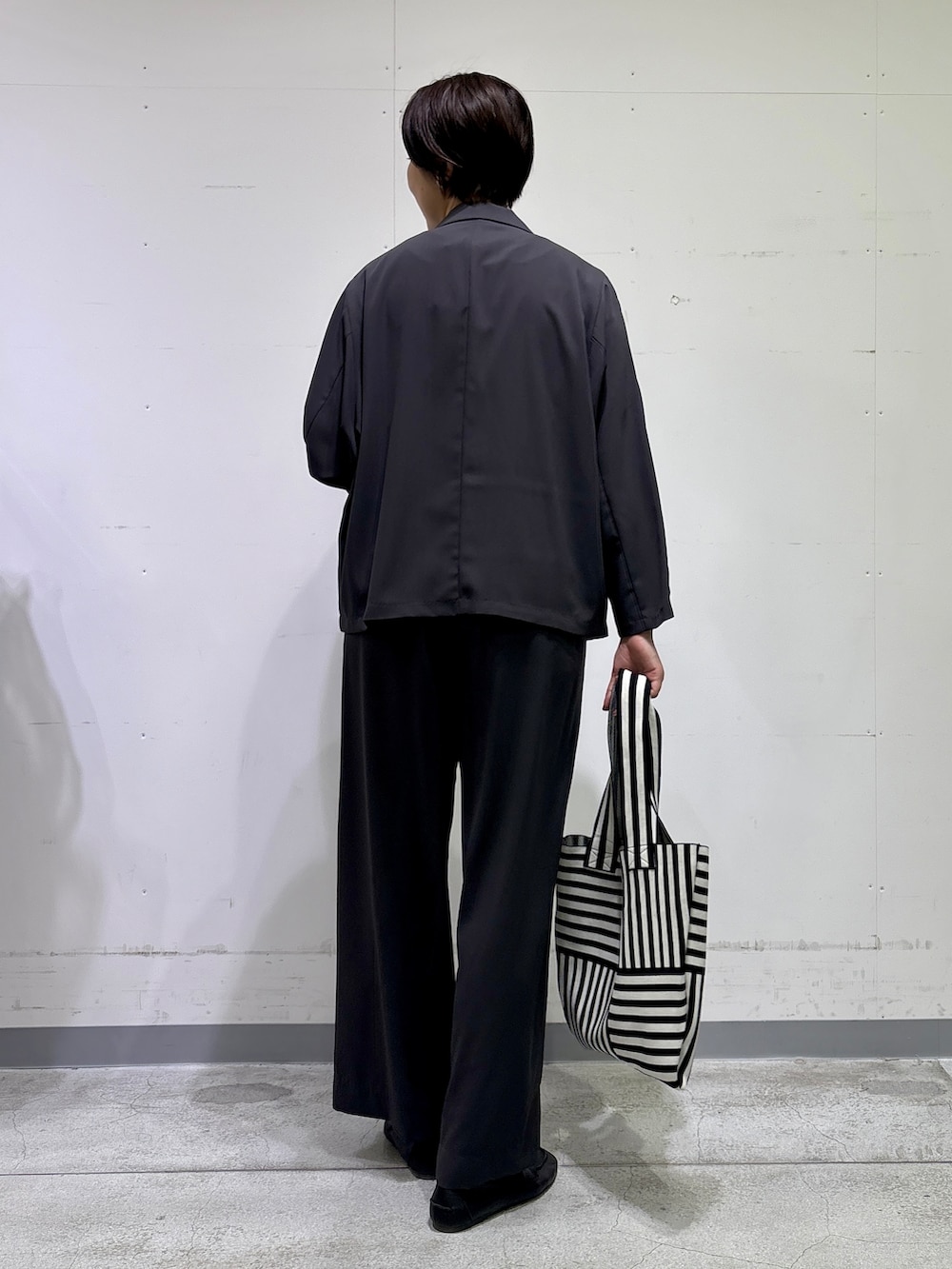 ブラック系のトートバッグ、ホワイト系のTシャツ/カットソー、グレー系のその他パンツを着用したレディースの春コーディネートの4枚目の写真