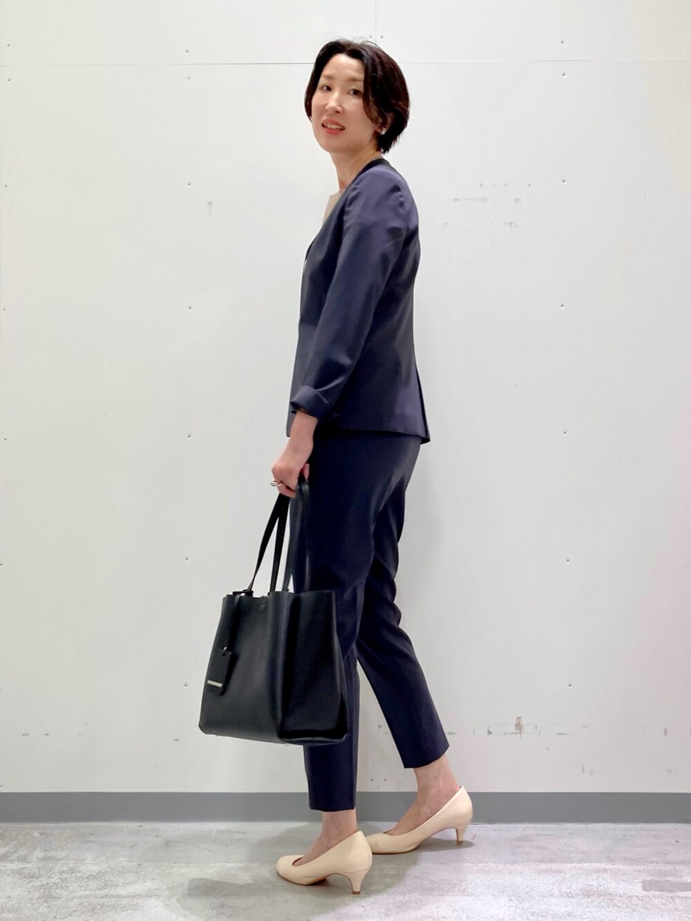 ホワイト系のシャツ/ブラウス、グレー系のスーツジャケット、グレー系のスーツパンツを着用したレディースの秋コーディネートの5枚目の写真