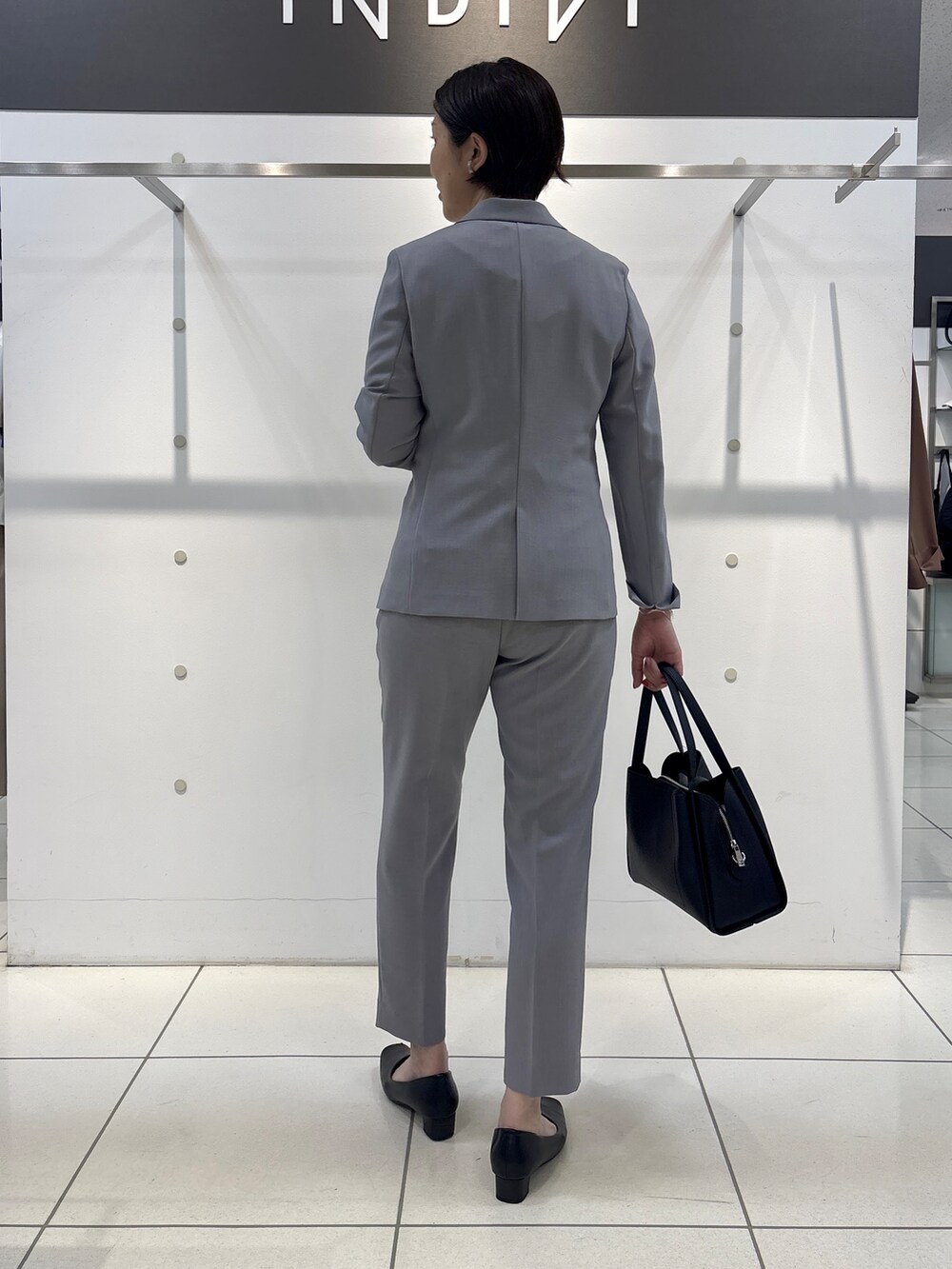 グレー系のスーツジャケット、グレー系のシャツ/ブラウス、グレー系のスーツパンツを着用したレディースの夏コーディネートの4枚目の写真
