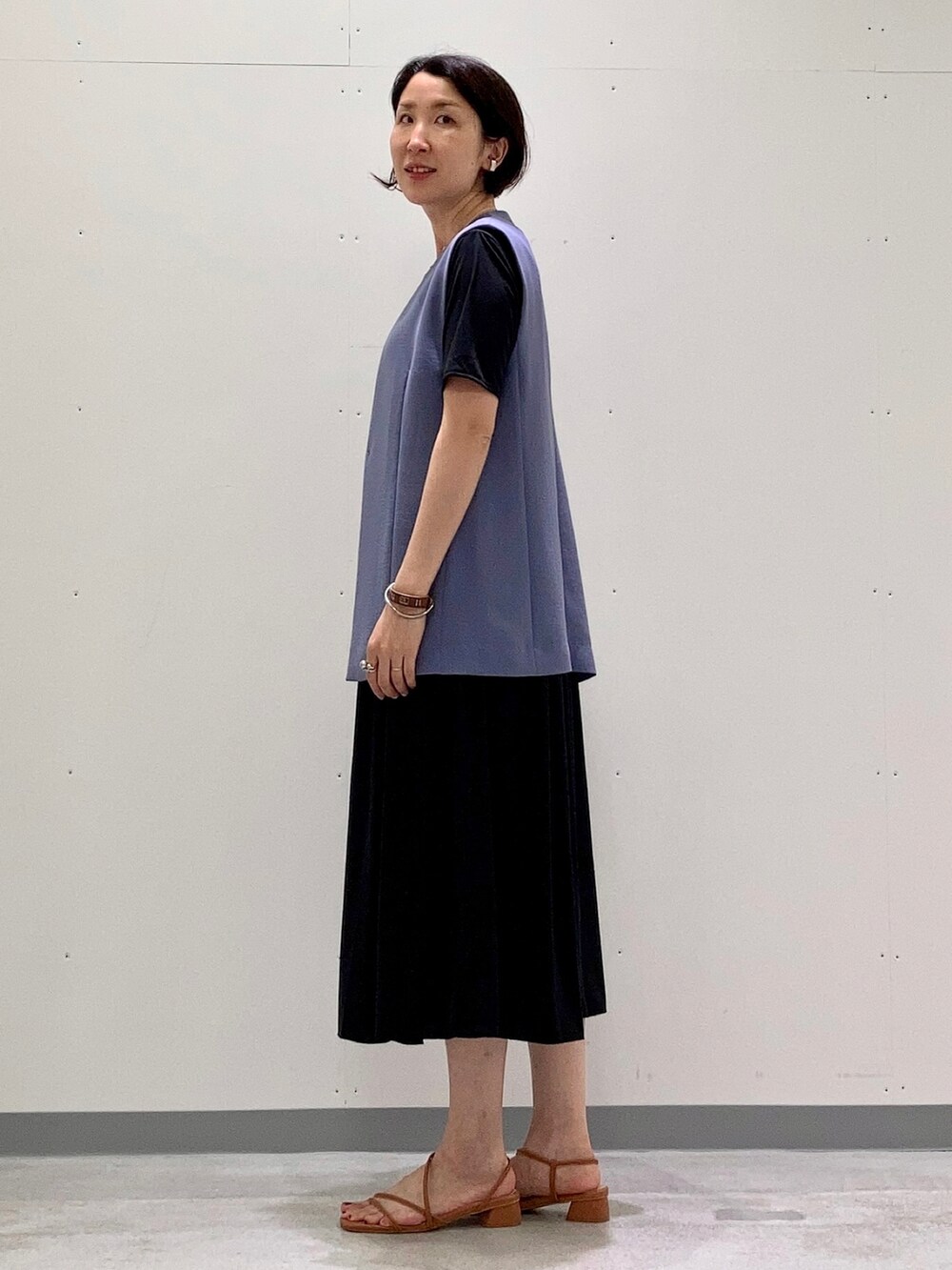 ブラック系のワンピース、ブルー系のベスト、ブラック系のショルダーバッグを着用したレディースの夏コーディネートの2枚目の写真