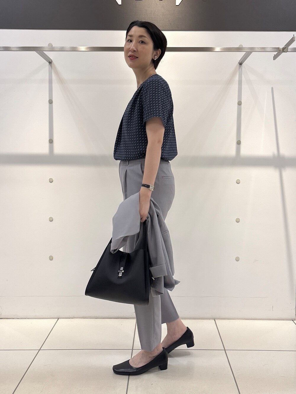 グレー系のスーツジャケット、グレー系のシャツ/ブラウス、グレー系のスーツパンツを着用したレディースの夏コーディネートの9枚目の写真