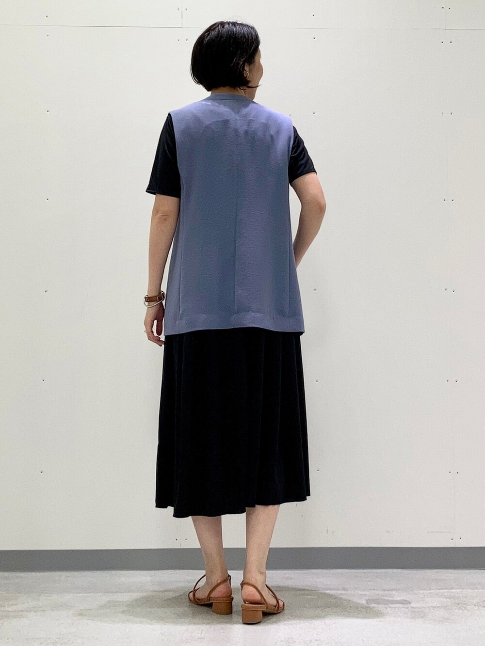 ブラック系のワンピース、ブルー系のベスト、ブラック系のショルダーバッグを着用したレディースの夏コーディネートの3枚目の写真