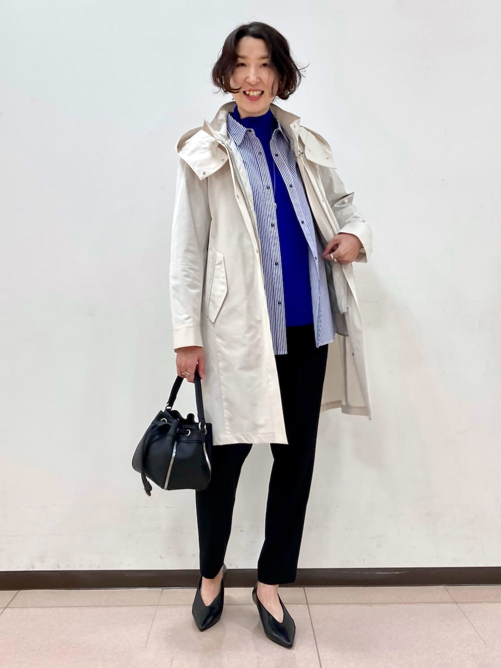 ブラウン系のパンプス、ホワイト系のモッズコート、ブラック系のその他パンツを着用したレディースの冬コーディネートの5枚目の写真