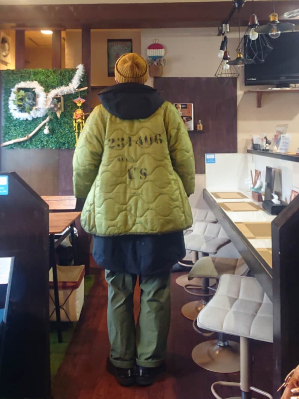 ブラック系のスニーカー、グリーン系のカーゴパンツ、ブラック系のモッズコートを着用したメンズの秋コーディネートの3枚目の写真