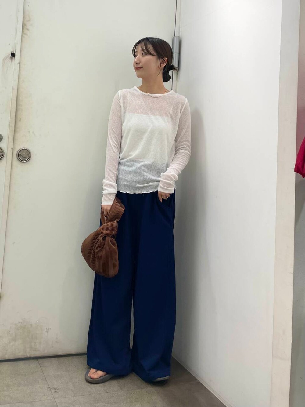 ホワイト系のキャミソール、ブラウン系のハンドバッグ、ホワイト系のTシャツ/カットソーを着用したレディースの秋コーディネートの2枚目の写真