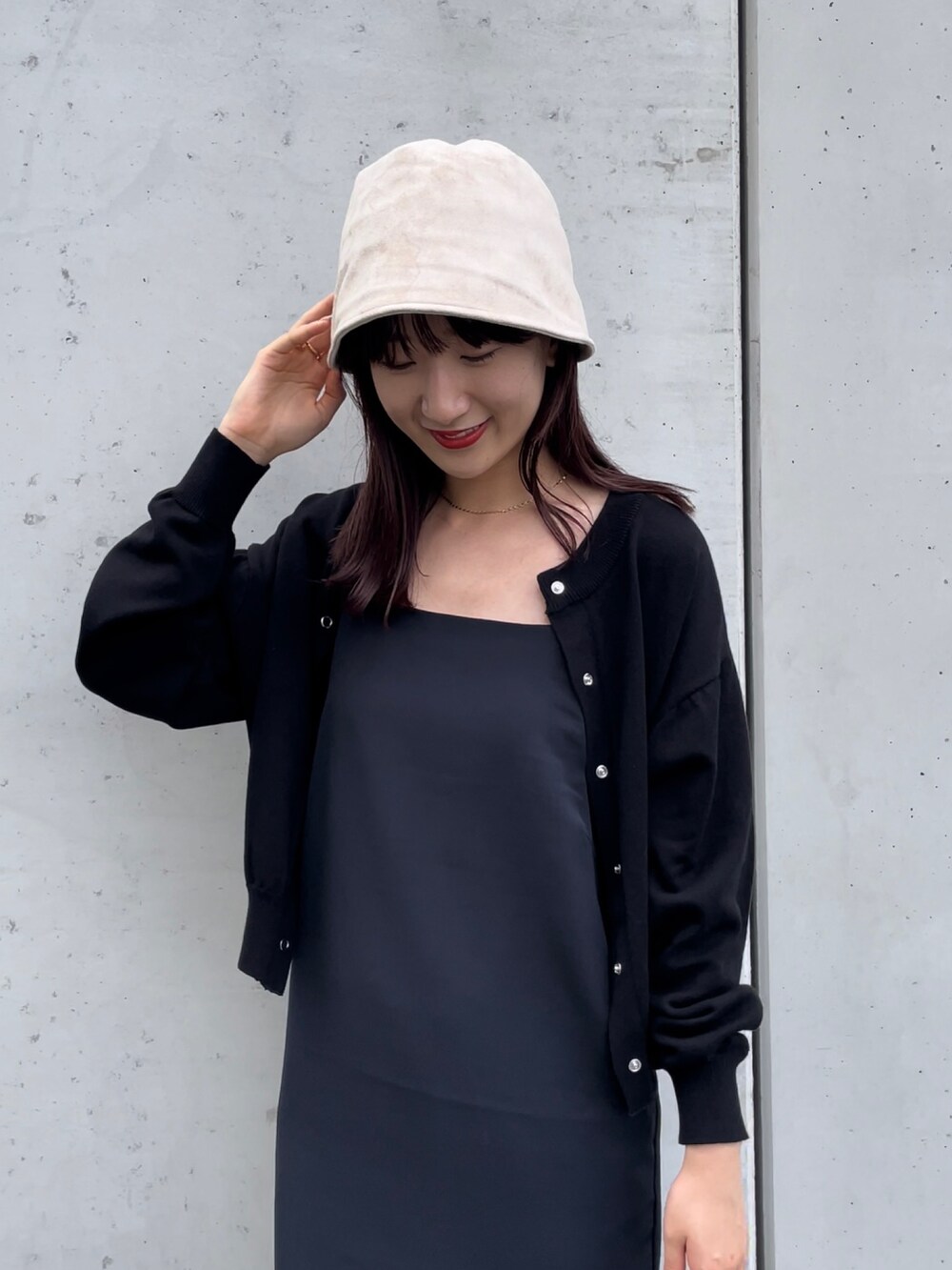 ブラック系のワンピース、ブラック系のカーディガン/ボレロ、ベージュ系のハットを着用したレディースの秋コーディネートの2枚目の写真