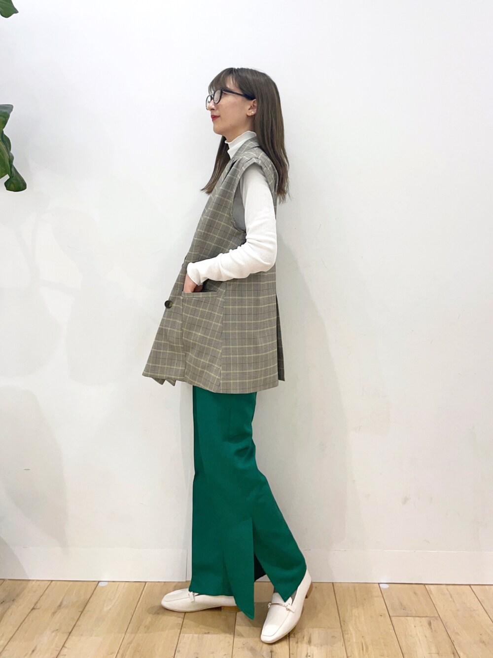 その他のベスト、ホワイト系のTシャツ/カットソー、グリーン系のスラックスを着用したレディースの冬コーディネートの2枚目の写真