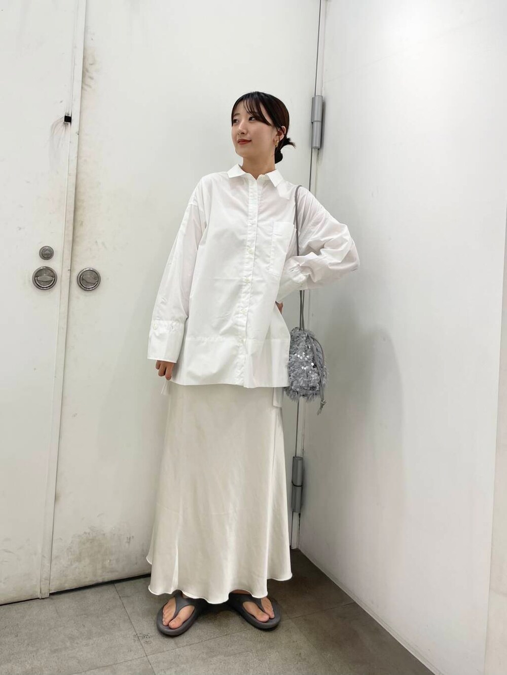 ホワイト系のキャミソール、ホワイト系のTシャツ/カットソー、グレー系のハンドバッグを着用したレディースの秋コーディネートの2枚目の写真