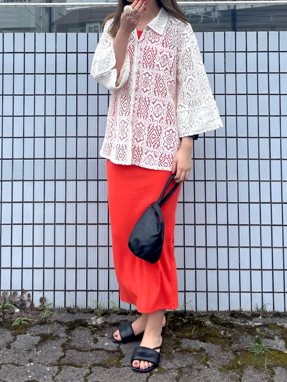 ブラック系のサンダル、ホワイト系のシャツ/ブラウス、ブラック系のハンドバッグを着用したレディースの夏コーディネートの2枚目の写真