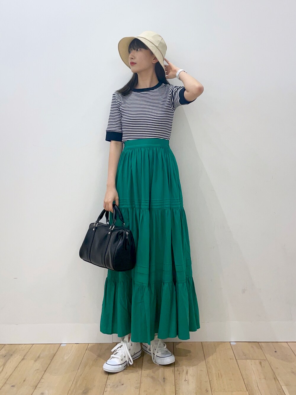 ブルー系のTシャツ/カットソー、グリーン系のスカート、ブラック系のボストンバッグを着用したレディースの春コーディネートの2枚目の写真