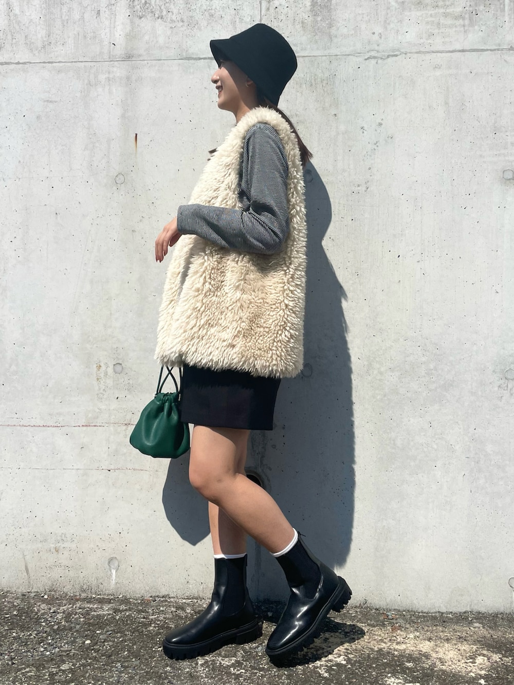 ホワイト系のベスト、ブラック系のTシャツ/カットソー、ブラック系のスラックスを着用したレディースの秋コーディネートの2枚目の写真