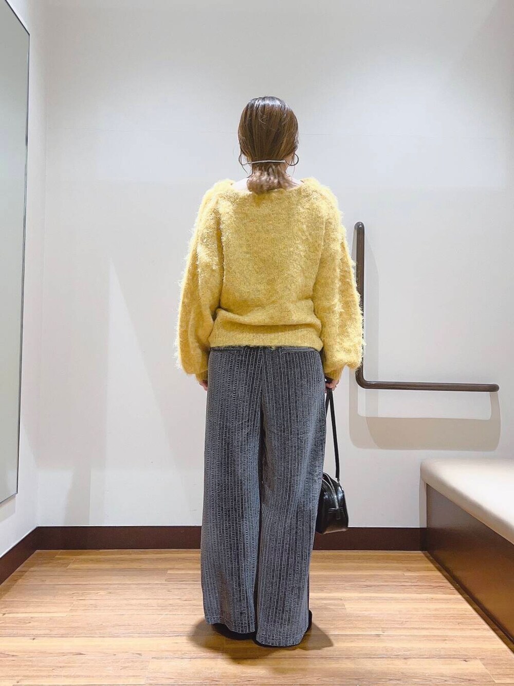 イエロー系のニット/セーター、ブラック系のその他シューズ、グレー系のその他パンツを着用したレディースの秋コーディネートの3枚目の写真