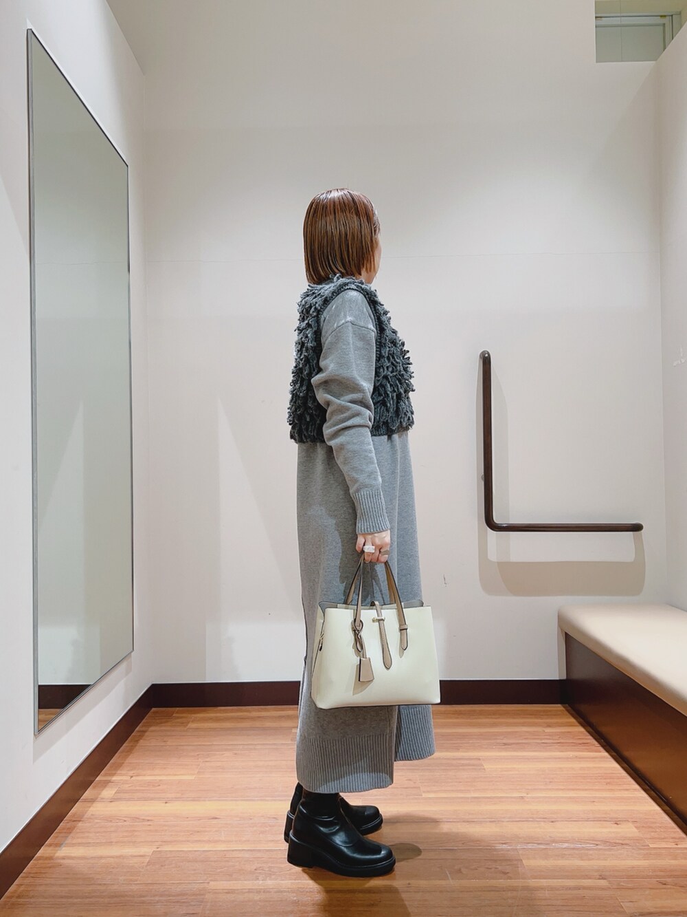 グレー系のワンピース、ホワイト系のトートバッグを着用したレディースの冬コーディネートの4枚目の写真