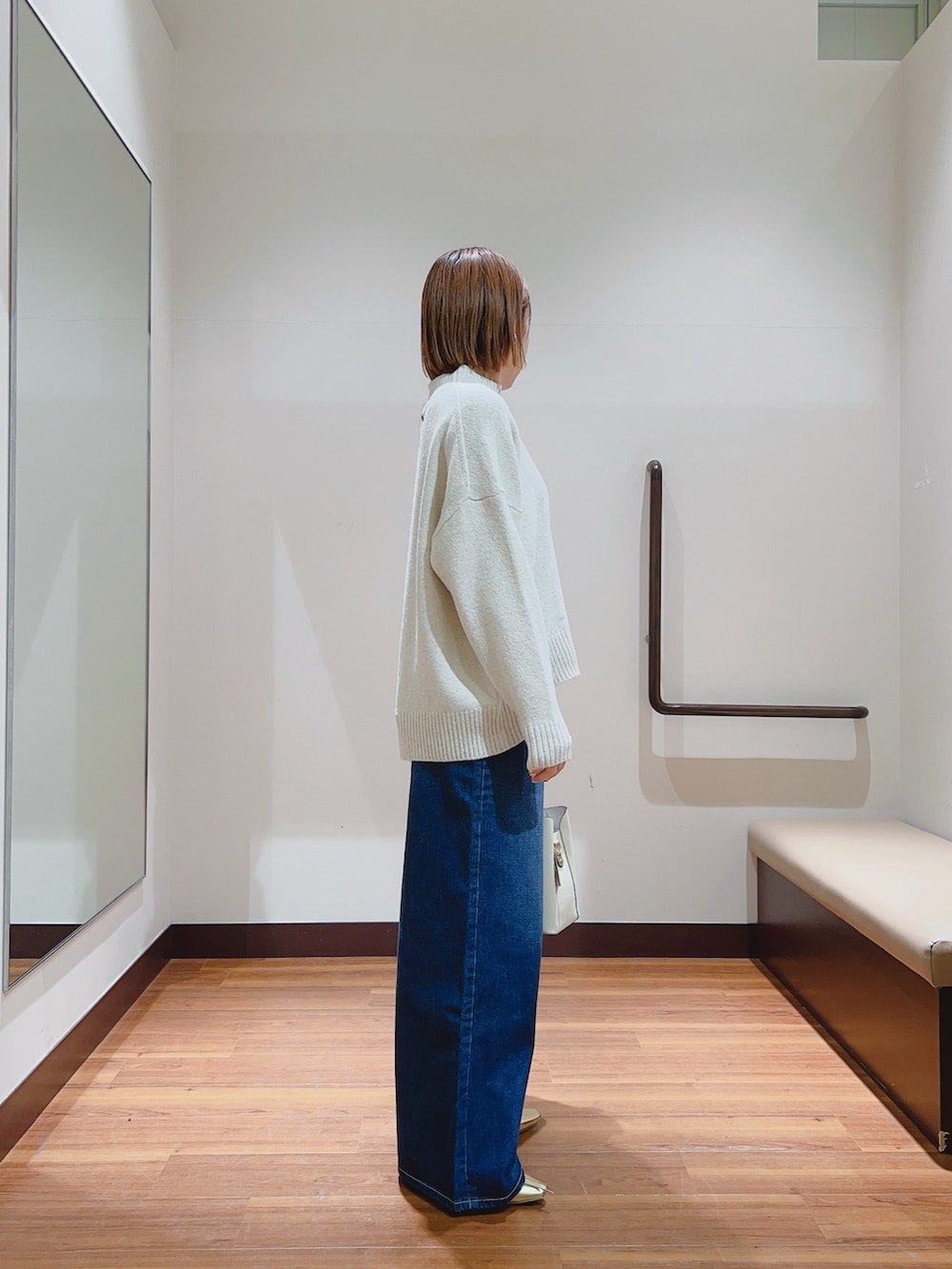 ホワイト系のニット/セーター、ブルー系のデニムパンツ、ホワイト系のトートバッグを着用したレディースの冬コーディネートの3枚目の写真