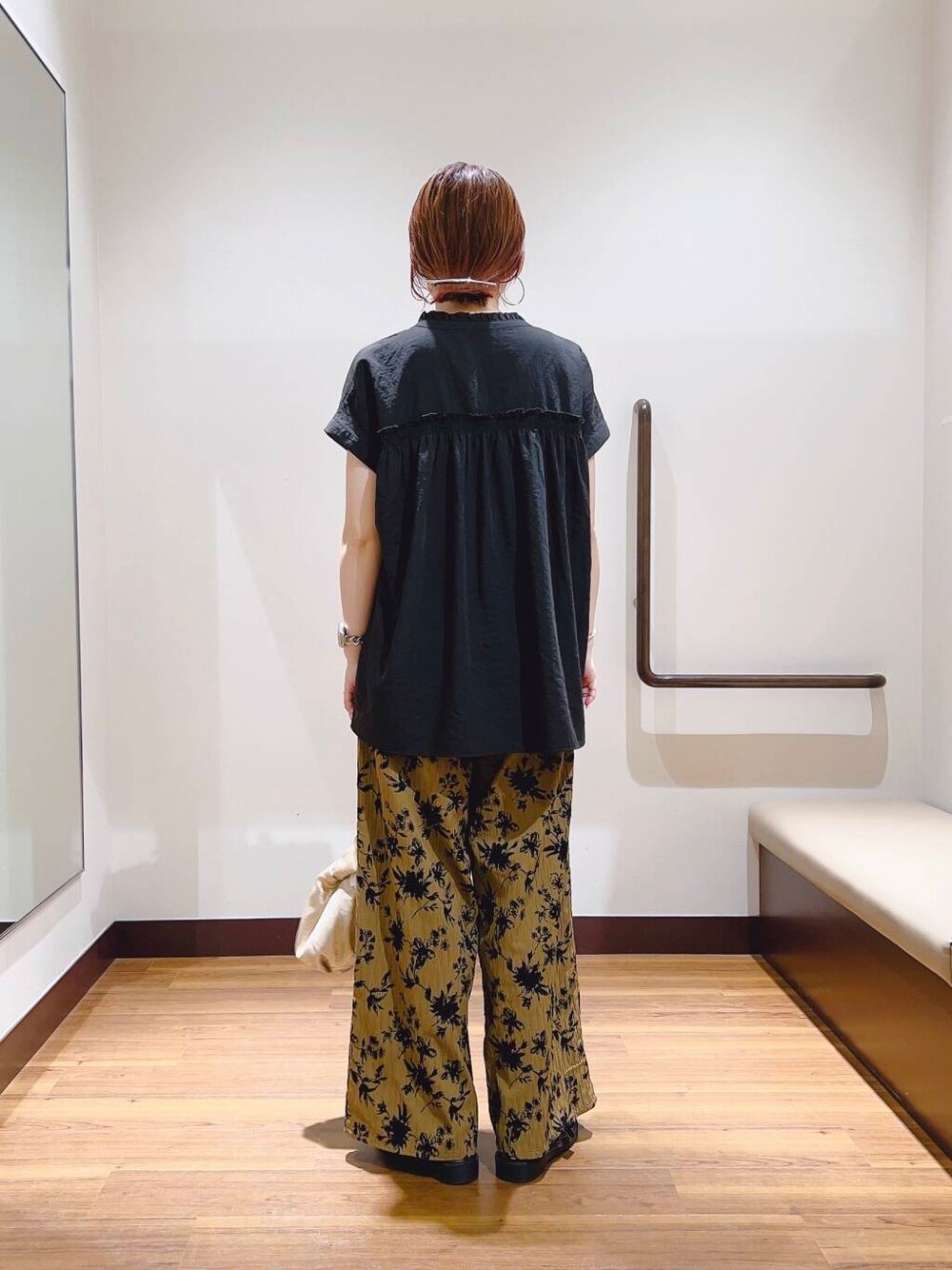 ゴールド系のハンドバッグ、ブラウン系のその他パンツを着用したレディースの夏コーディネートの3枚目の写真