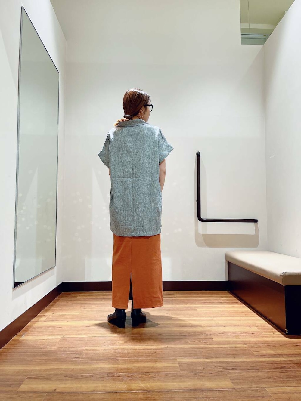 ブラック系のブーツ、ゴールド系のショルダーバッグ、オレンジ系のスカートを着用したレディースの秋コーディネートの4枚目の写真