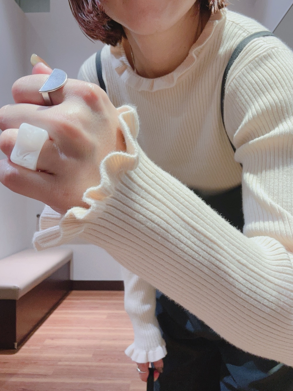 グレー系のサロペット/オーバーオール、ホワイト系のニット/セーター、ブラック系のハンドバッグを着用したレディースの秋コーディネートの6枚目の写真