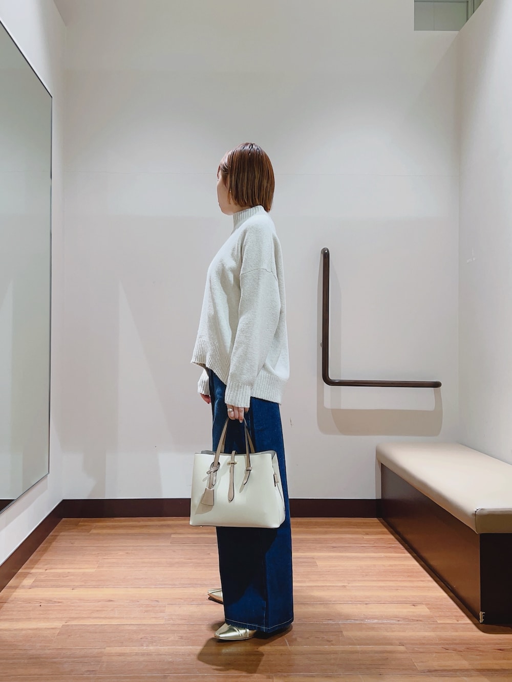 ホワイト系のニット/セーター、ブルー系のデニムパンツ、ホワイト系のトートバッグを着用したレディースの冬コーディネートの2枚目の写真