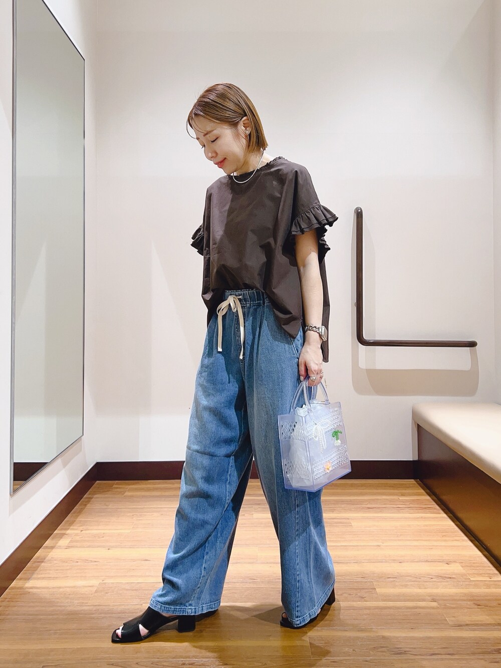 ブラウン系のシャツ/ブラウス、ブルー系のデニムパンツ、その他のハンドバッグを着用したレディースの夏コーディネートの2枚目の写真