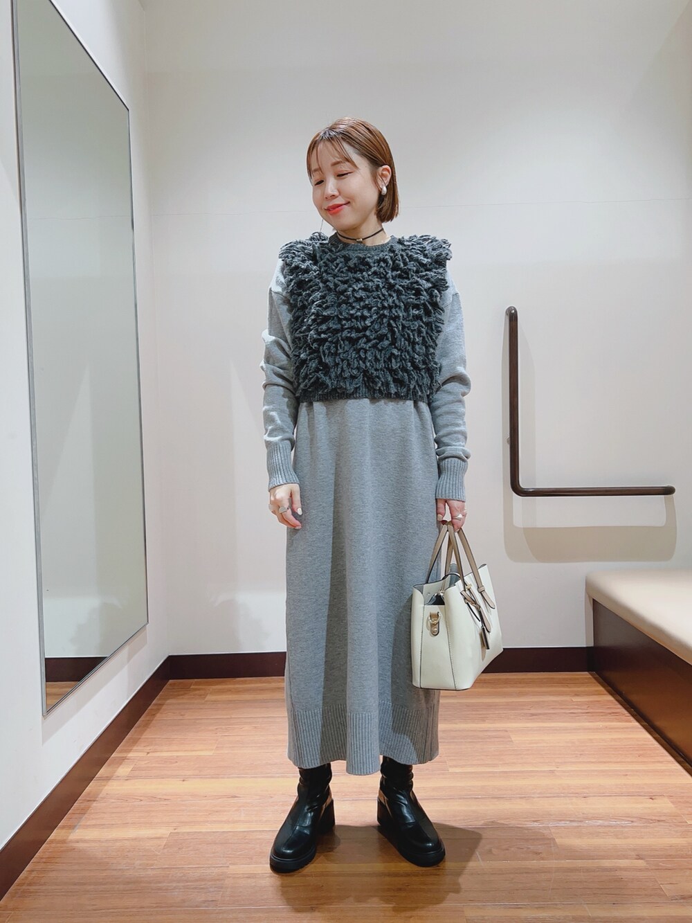 グレー系のワンピース、ホワイト系のトートバッグを着用したレディースの冬コーディネートの2枚目の写真