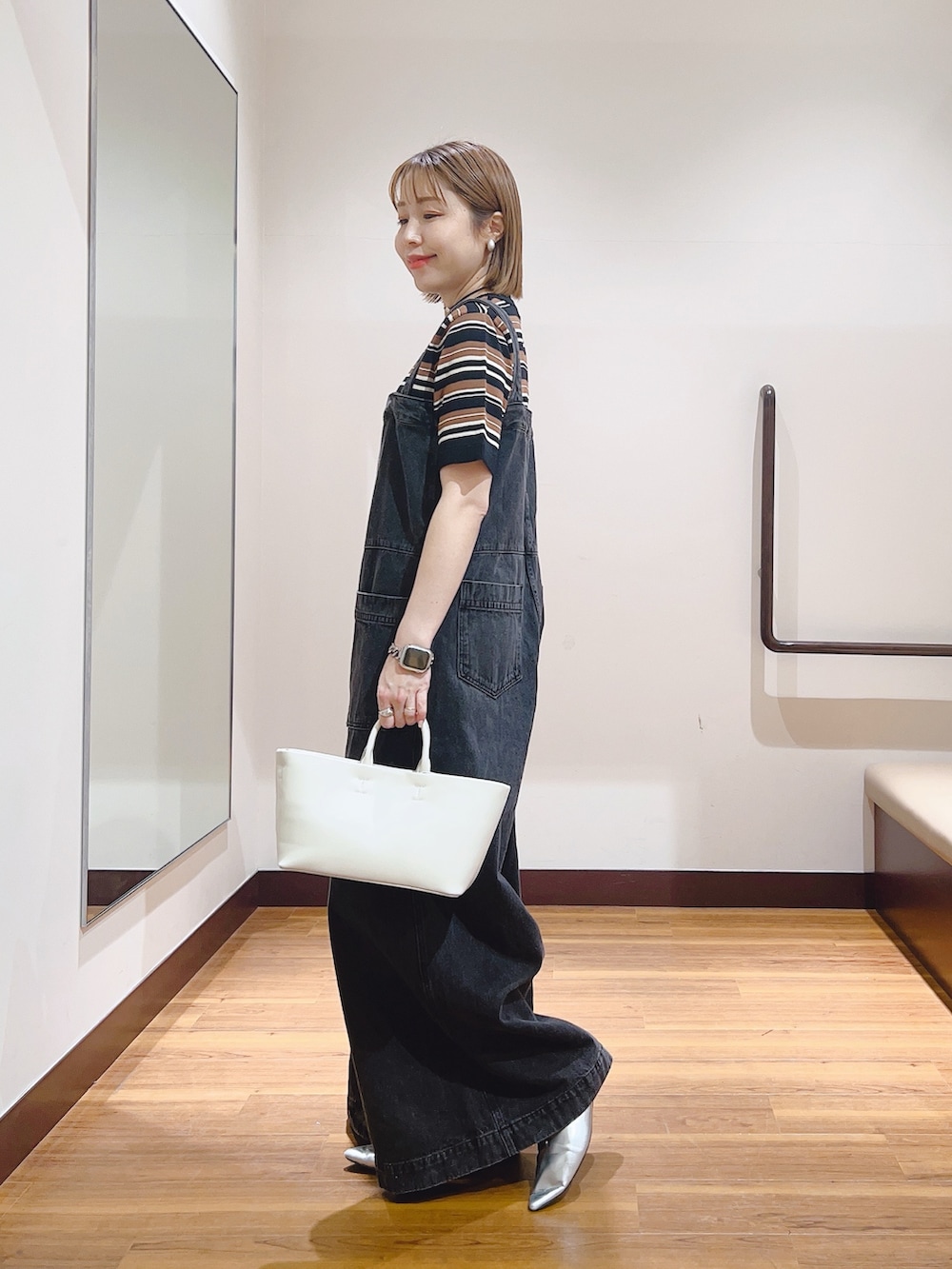 ブラウン系のニット/セーター、ホワイト系のトートバッグ、ブラック系のサロペット/オーバーオールを着用したレディースの春コーディネートの3枚目の写真