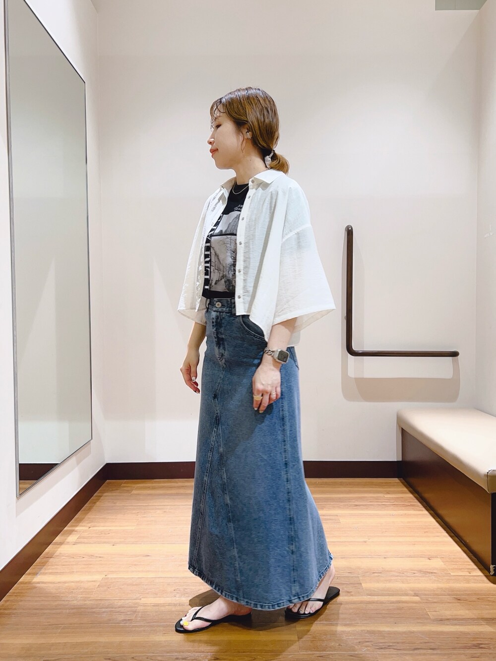 ホワイト系のシャツ/ブラウス、ブラック系のTシャツ/カットソー、ブルー系のデニムスカートを着用したレディースの春コーディネートの5枚目の写真