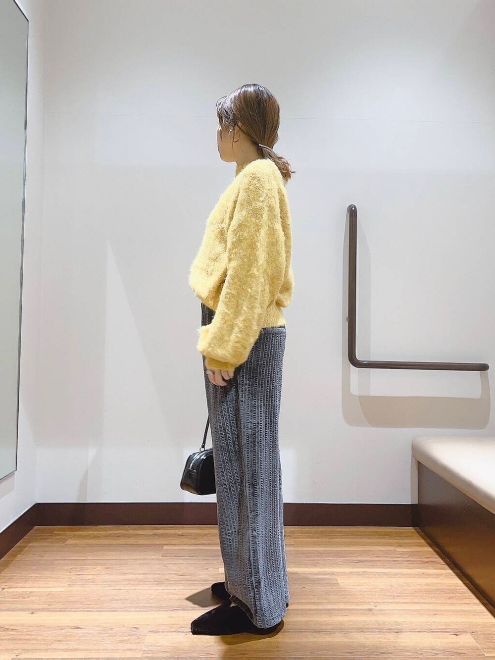 イエロー系のニット/セーター、ブラック系のその他シューズ、グレー系のその他パンツを着用したレディースの秋コーディネートの2枚目の写真