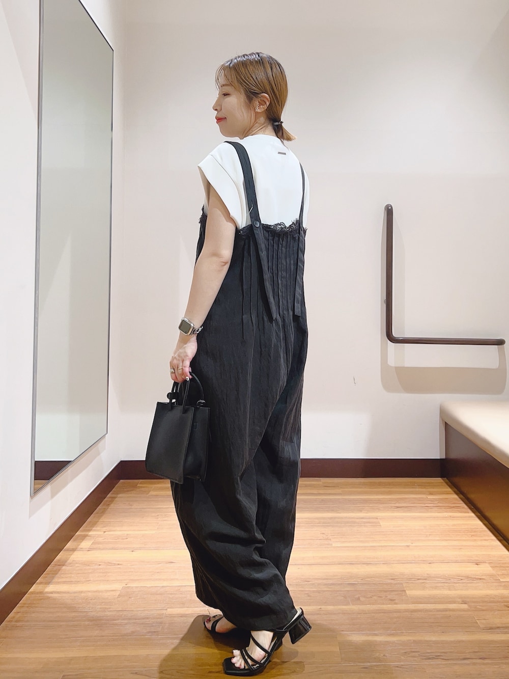 ホワイト系のハンドバッグ、ホワイト系のTシャツ/カットソー、ブラック系のその他パンツを着用したレディースの夏コーディネートの3枚目の写真