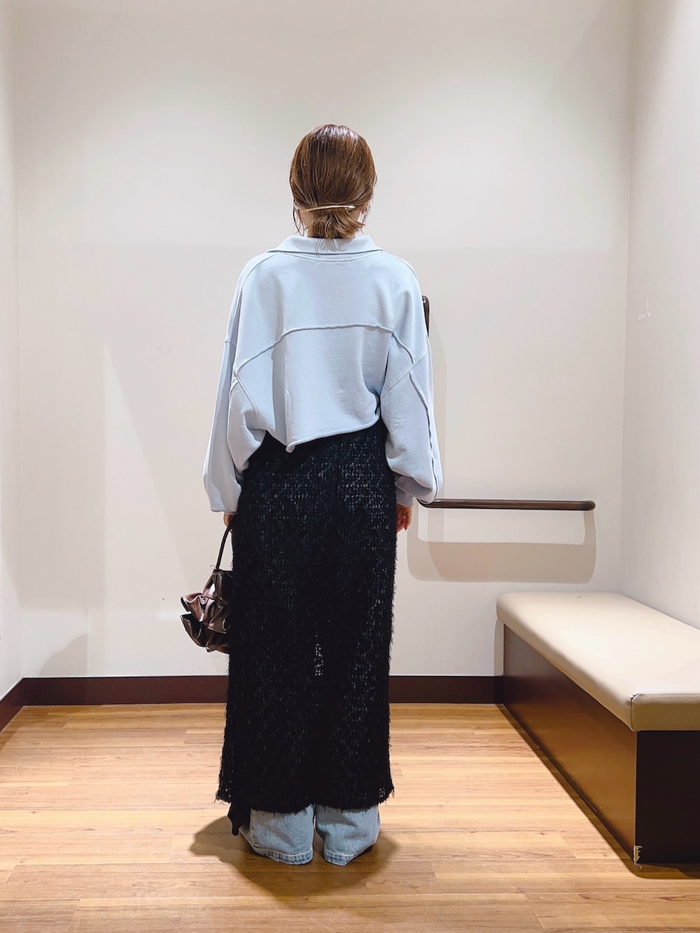 ブルー系のデニムパンツ、ブルー系のスウェット、ブラック系のスカートを着用したレディースの秋コーディネートの4枚目の写真