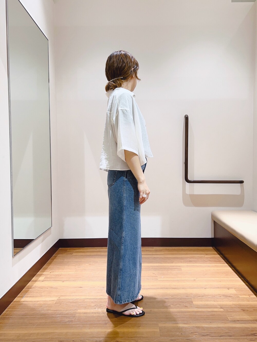 ホワイト系のシャツ/ブラウス、ブラック系のTシャツ/カットソー、ブルー系のデニムスカートを着用したレディースの春コーディネートの4枚目の写真