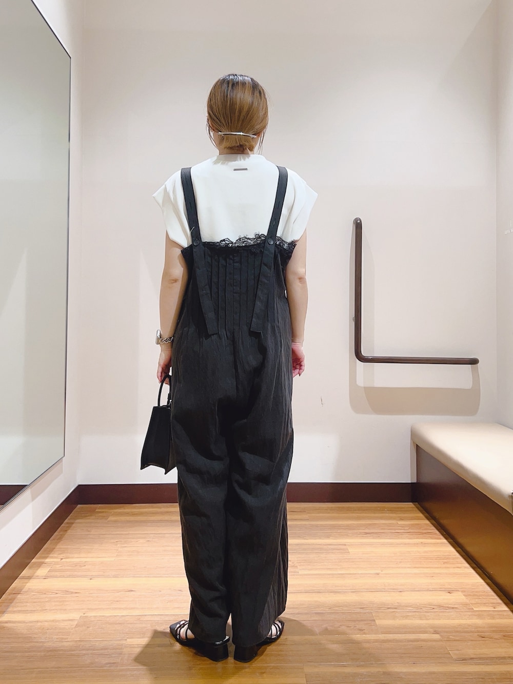 ホワイト系のハンドバッグ、ホワイト系のTシャツ/カットソー、ブラック系のその他パンツを着用したレディースの夏コーディネートの4枚目の写真