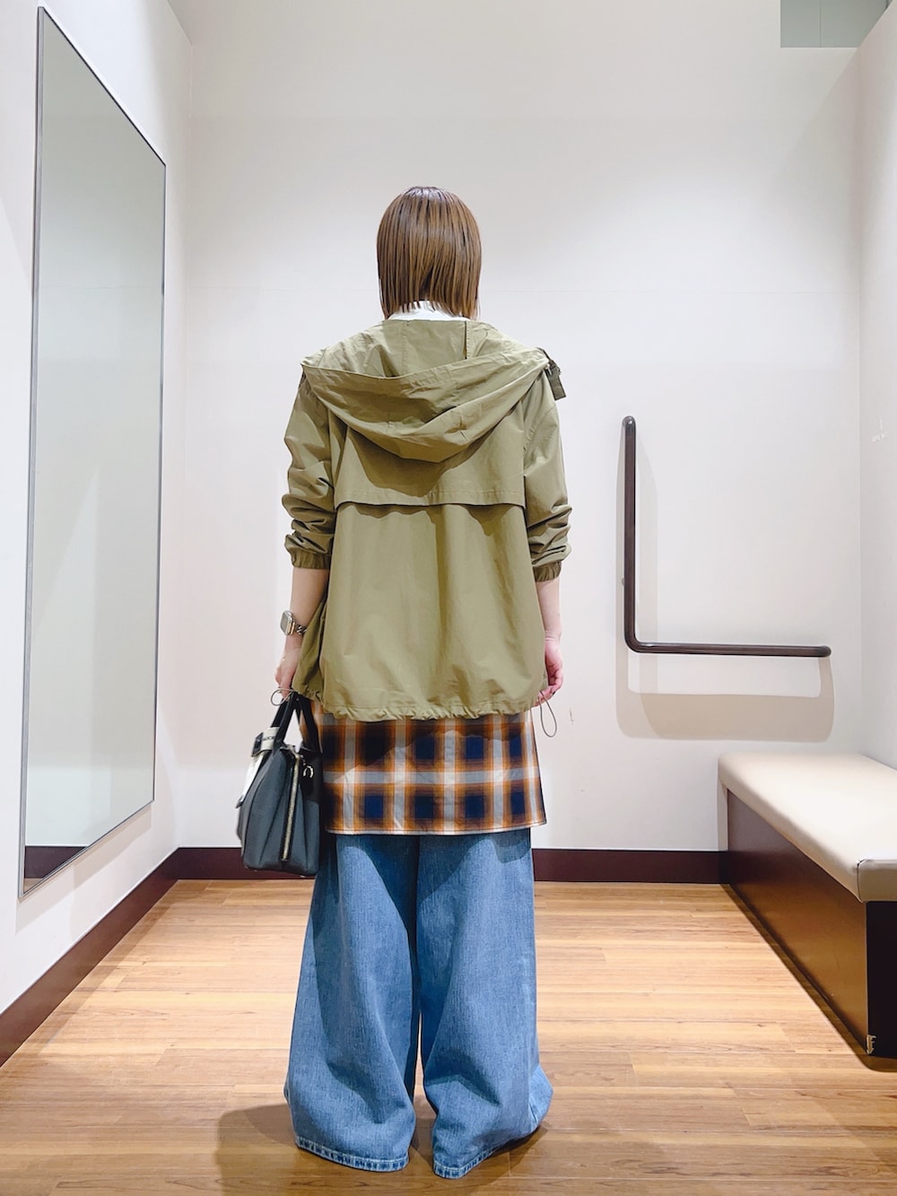 ブルー系のデニムパンツ、ブラック系のハンドバッグ、ホワイト系のマウンテンパーカーを着用したレディースの春コーディネートの5枚目の写真