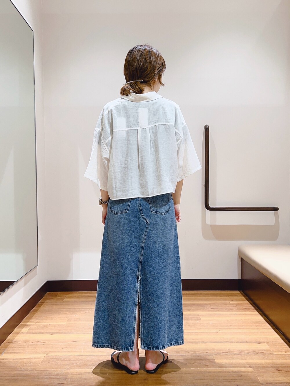 ホワイト系のシャツ/ブラウス、ブラック系のTシャツ/カットソー、ブルー系のデニムスカートを着用したレディースの春コーディネートの3枚目の写真